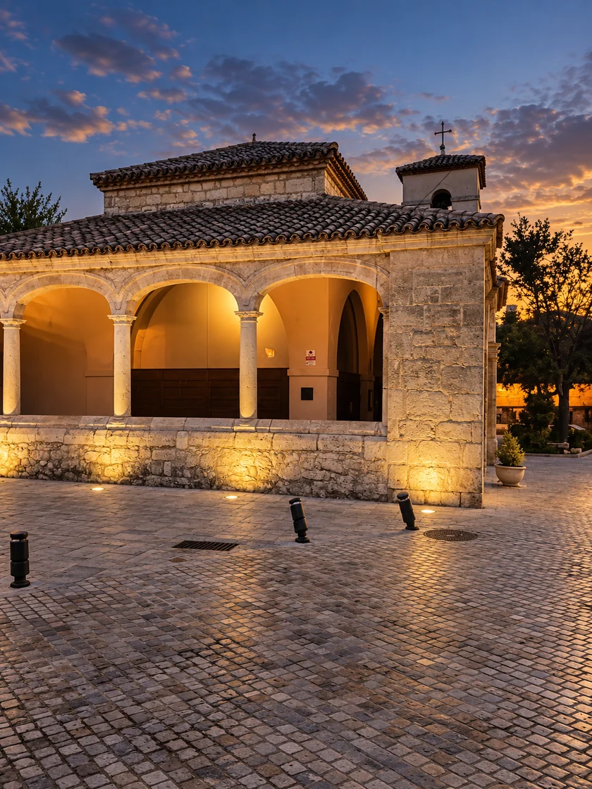 La iglesia vista desde la plaza, con la iluminación del muro exterior y del pórtico.